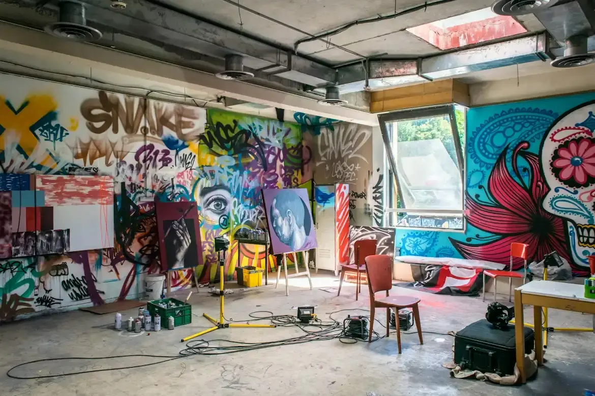 Atelier de peintre avec toiles sur chevalets et fresques murales colorées en arrière-plan