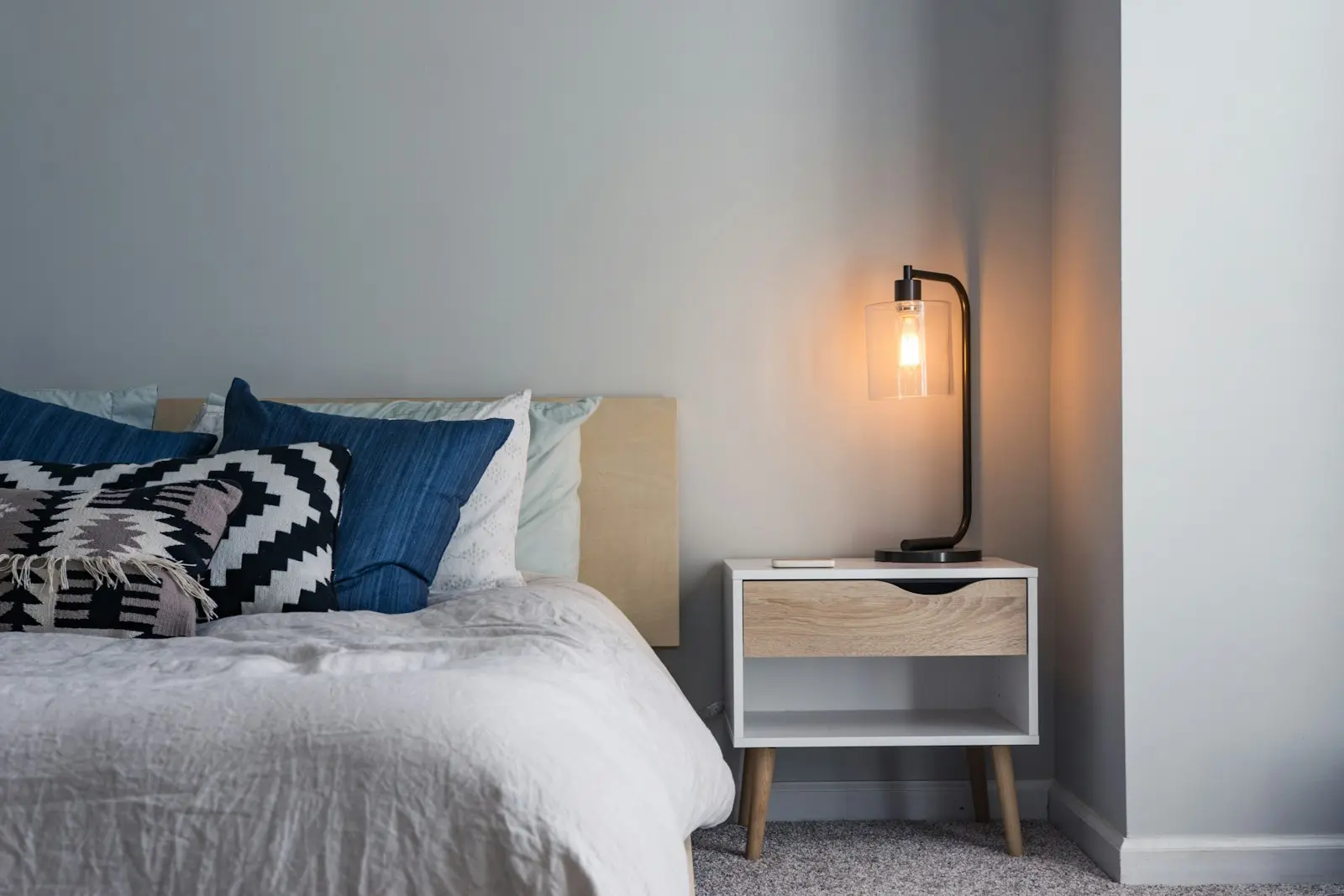 Chambre cosy avec lampe d'appoint allumée, préparée par une conciergerie pour les hôtes
