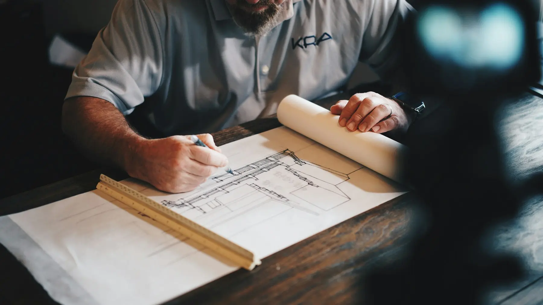Architecte dessinant un plan technique au crayon sur table à dessin