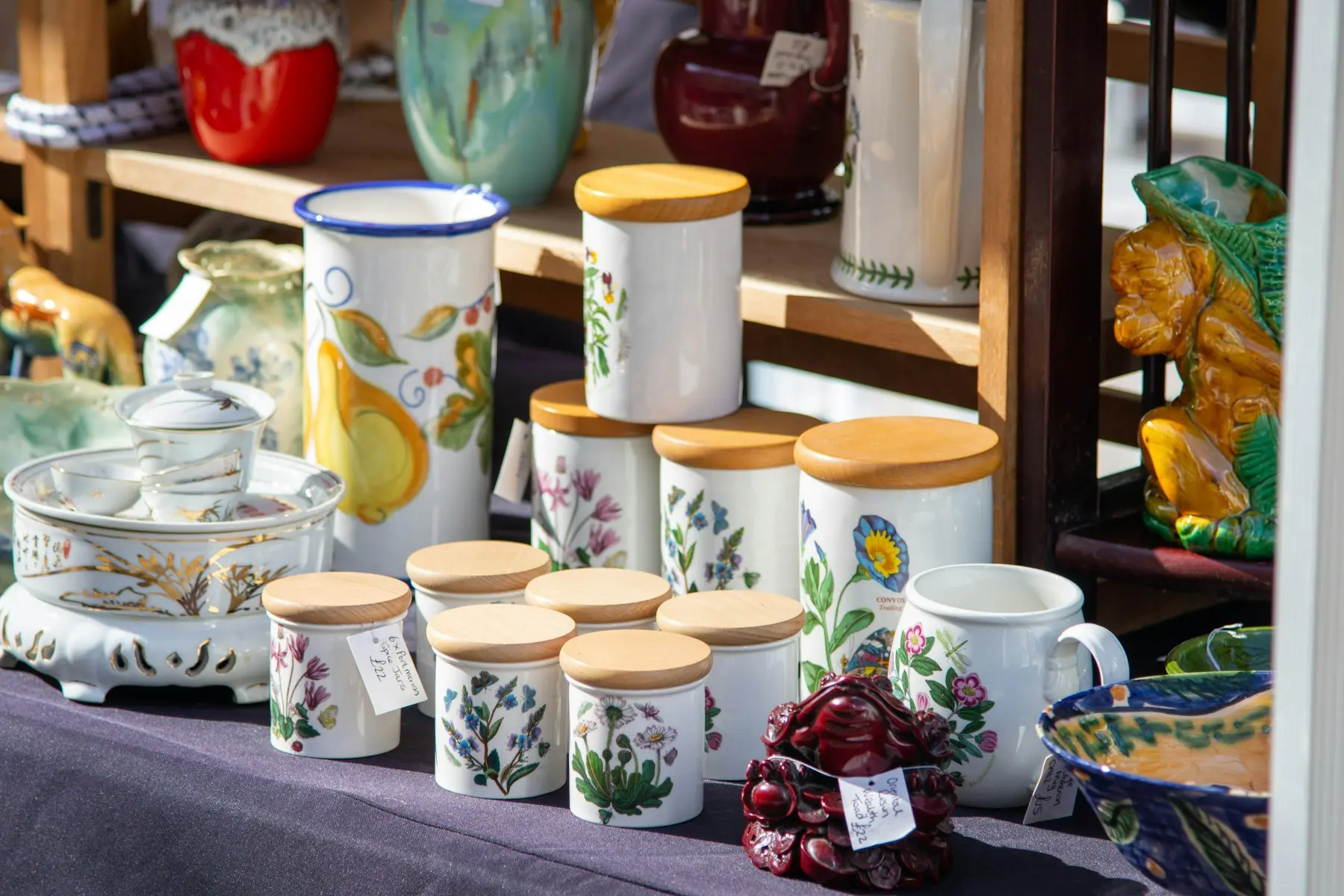Étal d'artisan céramiste avec vases et bocaux peints, idéal pour un site de création artisanale