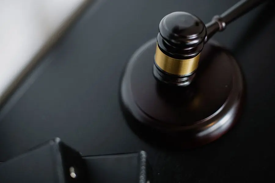 Marteau de juge en bois posé sur un bureau sombre