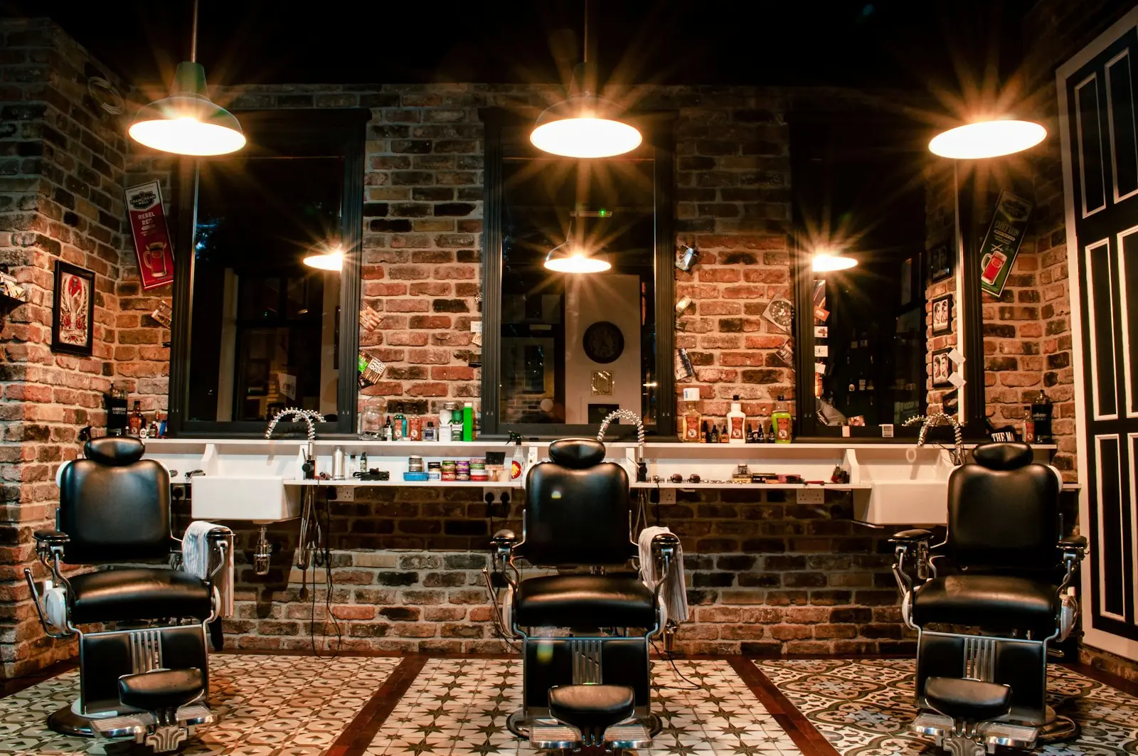 Intérieur d'un barbershop vintage avec fauteuils en cuir noir et mur en briques - création site internet barbershop