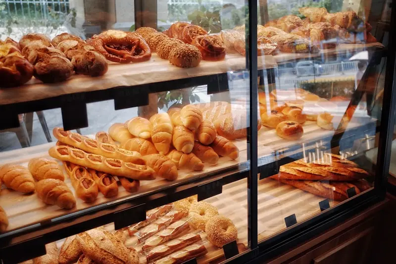 Vitrine de boulangerie garnie de viennoiseries, baguettes et pains artisanaux dorés