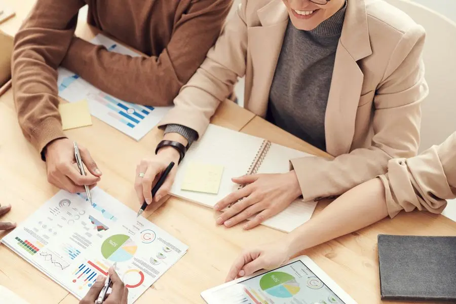 Équipe de consultants analysant des graphiques financiers autour d'une table de réunion