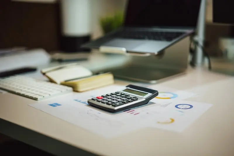 Bureau de comptable avec calculatrice, ordinateur portable et graphiques financiers