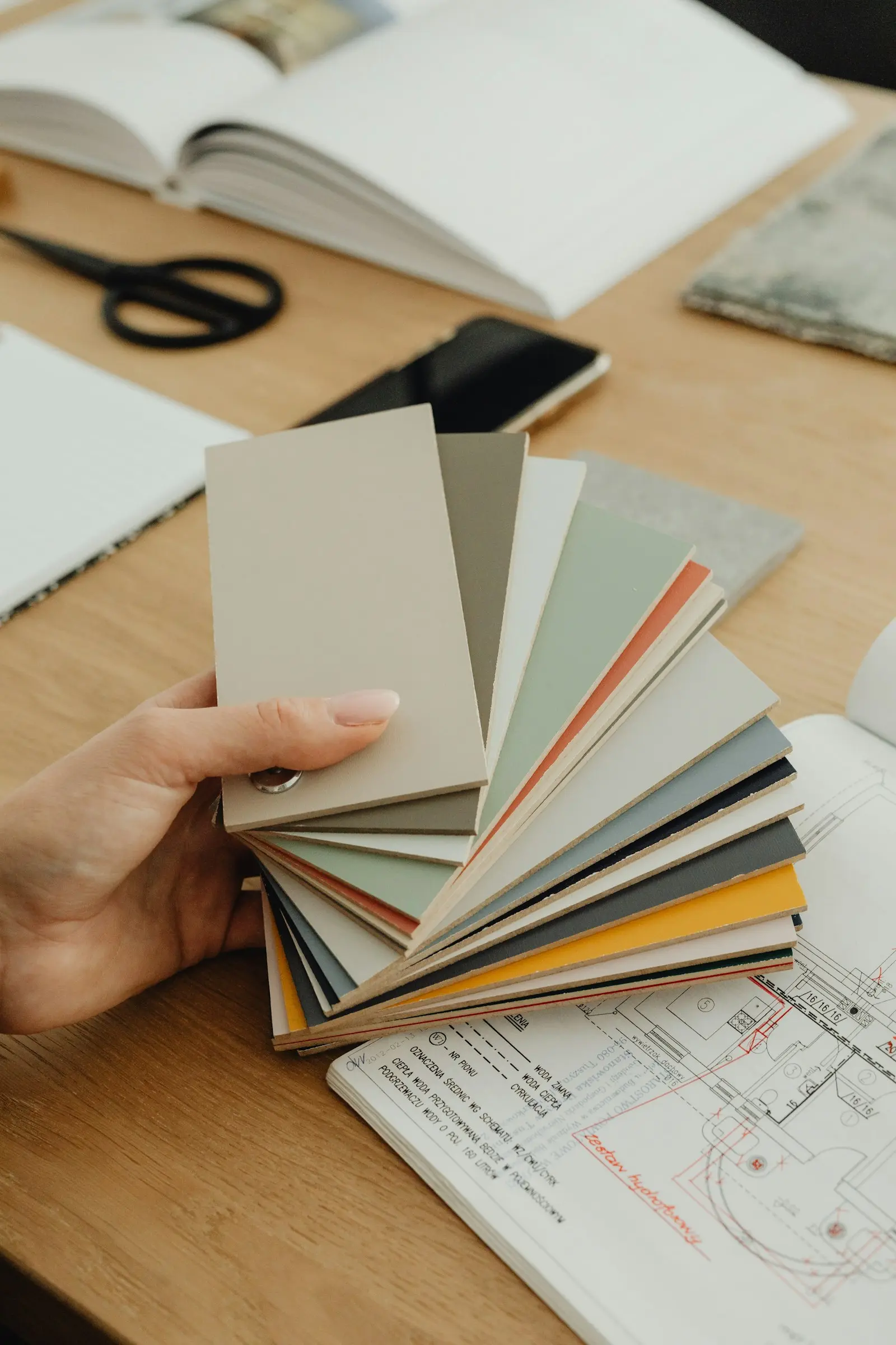 Designer d'intérieur sélectionnant des échantillons de couleurs sur un plan d'architecture