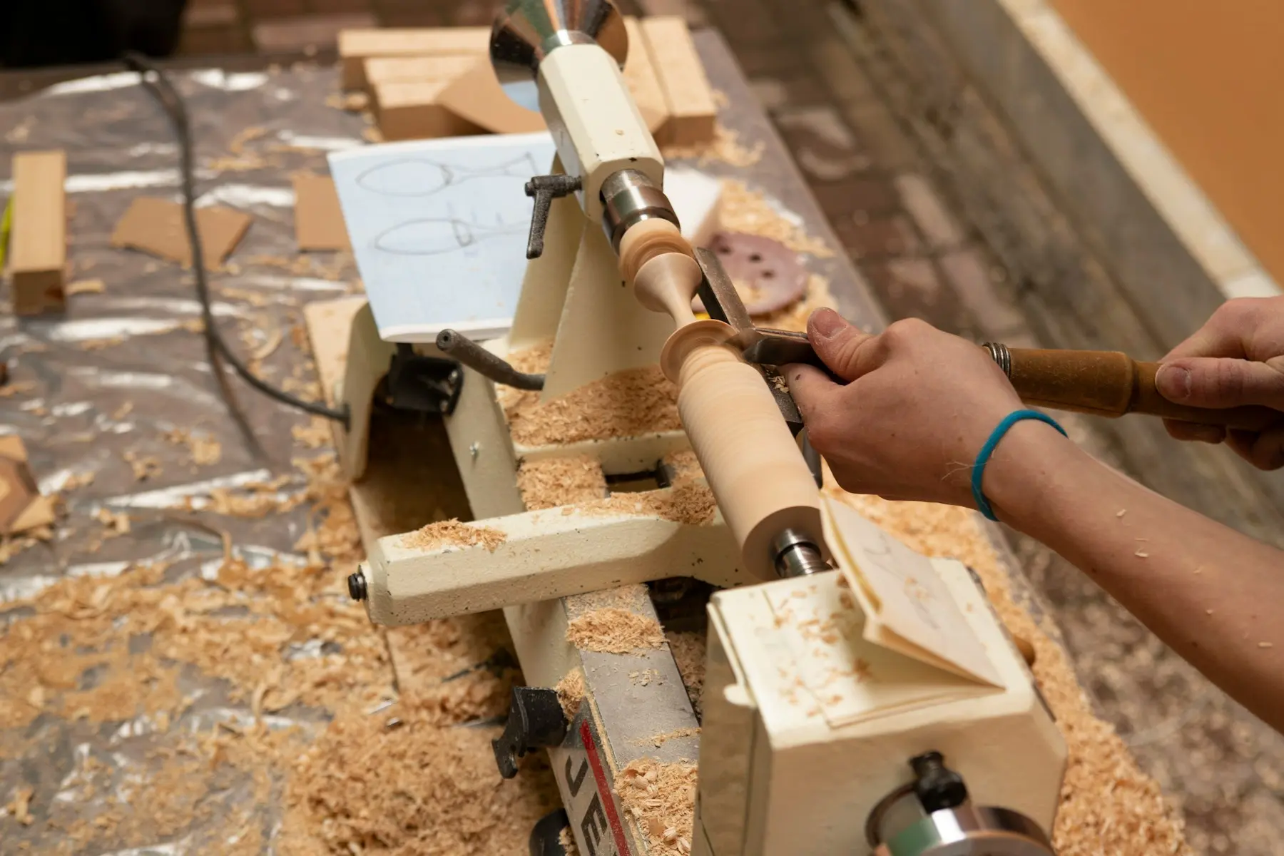 Ébéniste façonnant un pied de meuble sur un tour à bois, création de site internet pour artisan du bois