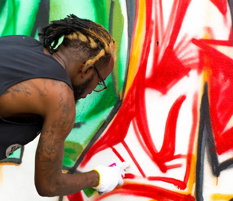 Création de site internet pour graffeur : artiste peignant une fresque murale colorée à la bombe aérosol
