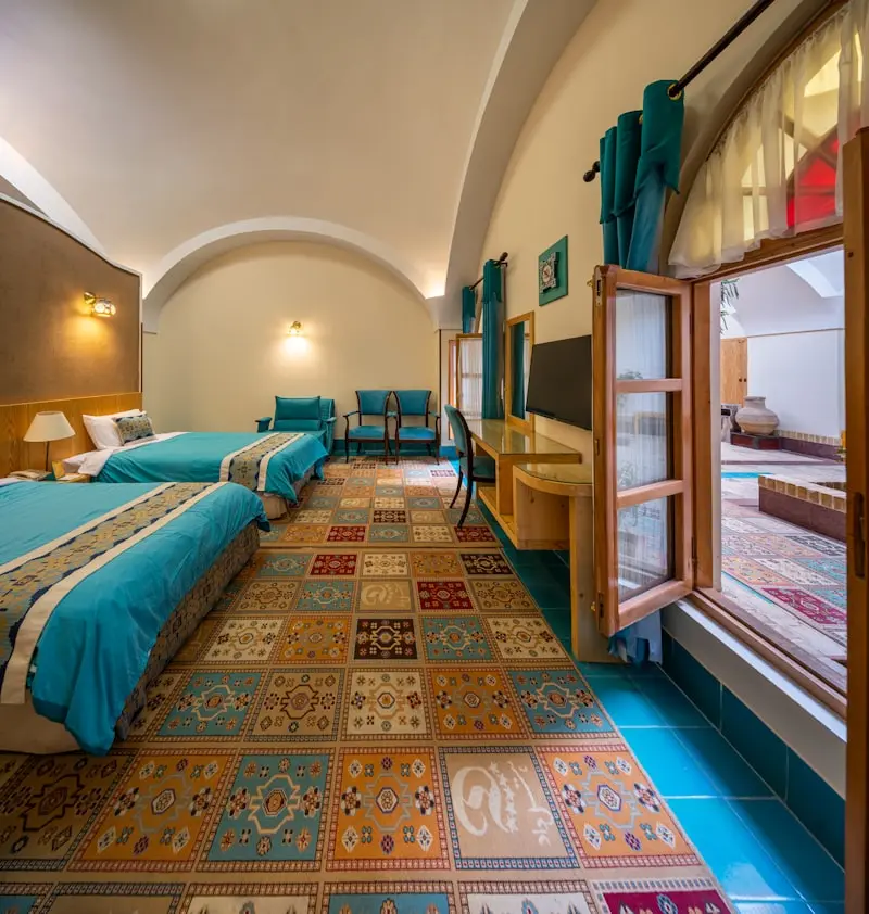 Chambre d'hôtel boutique décorée de bleu turquoise avec carrelage artisanal, idéal création site internet hôtel