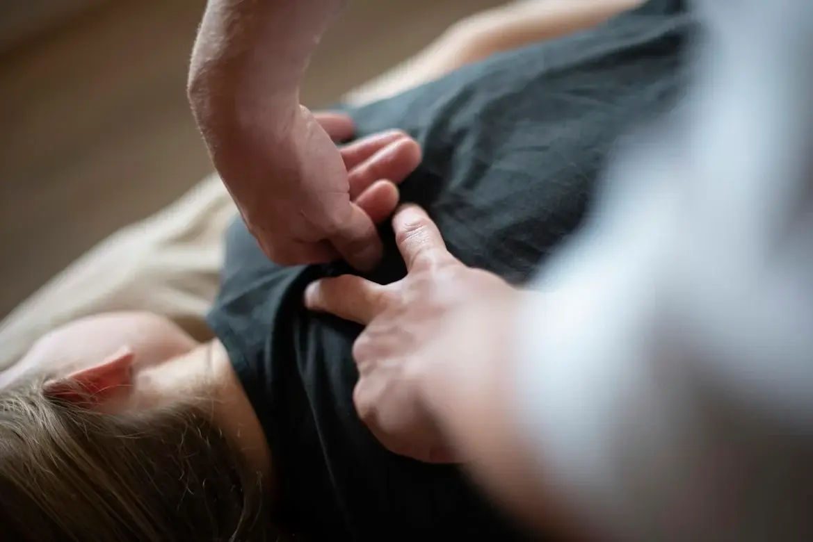 Kinésithérapeute manipulant l'épaule d'un patient lors d'une séance de rééducation