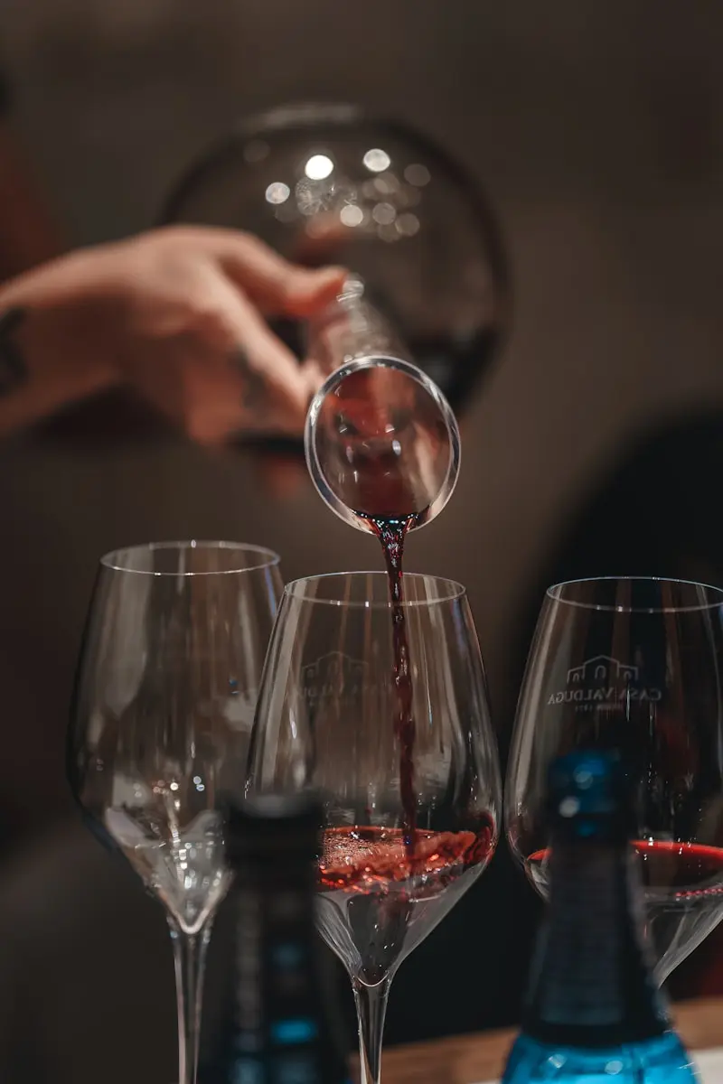 Sommelier versant délicatement du vin rouge dans un verre lors d'un service de dégustation