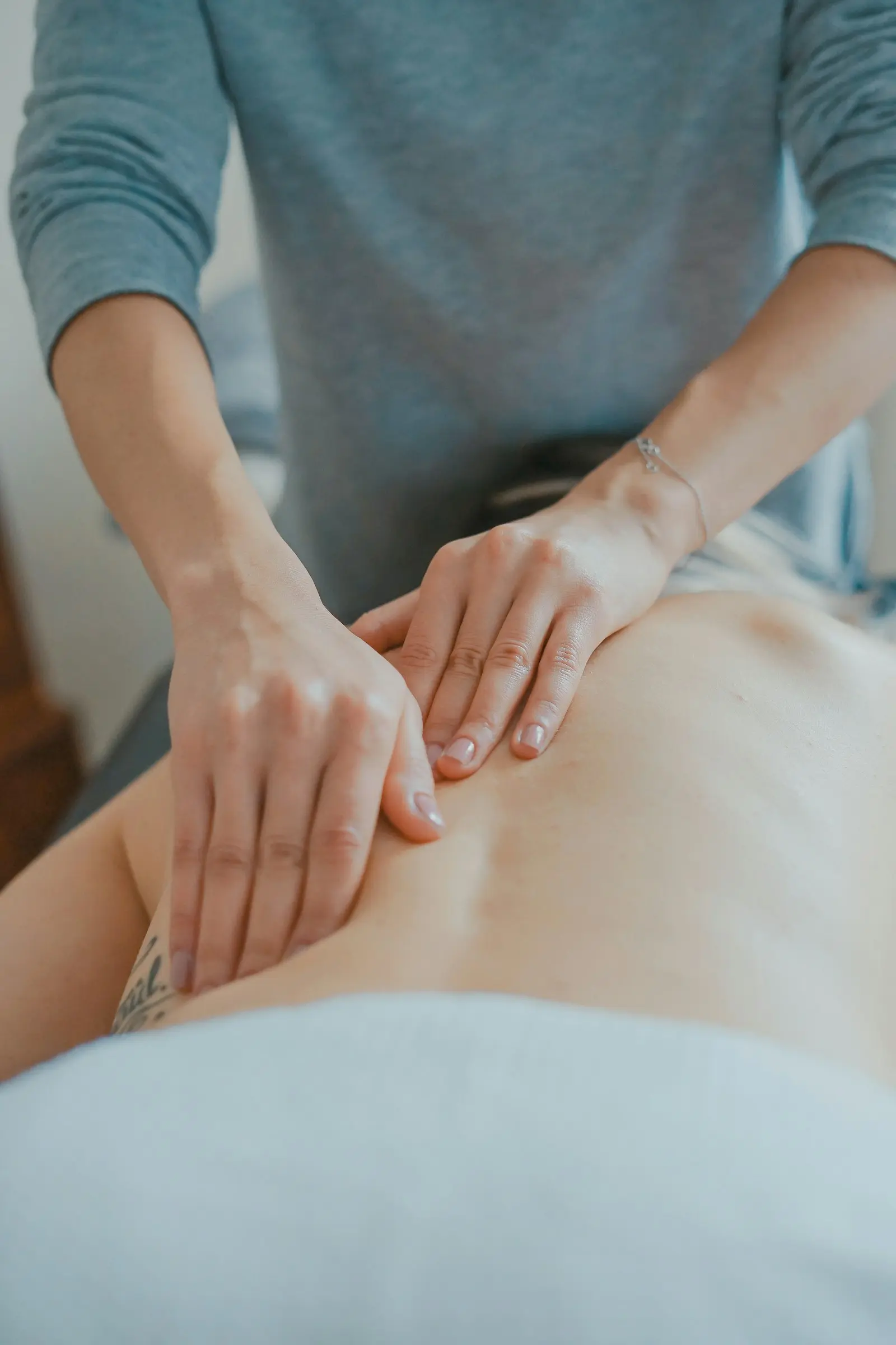 Praticienne prodiguant un soin du dos dans un institut de spa - création site internet spa