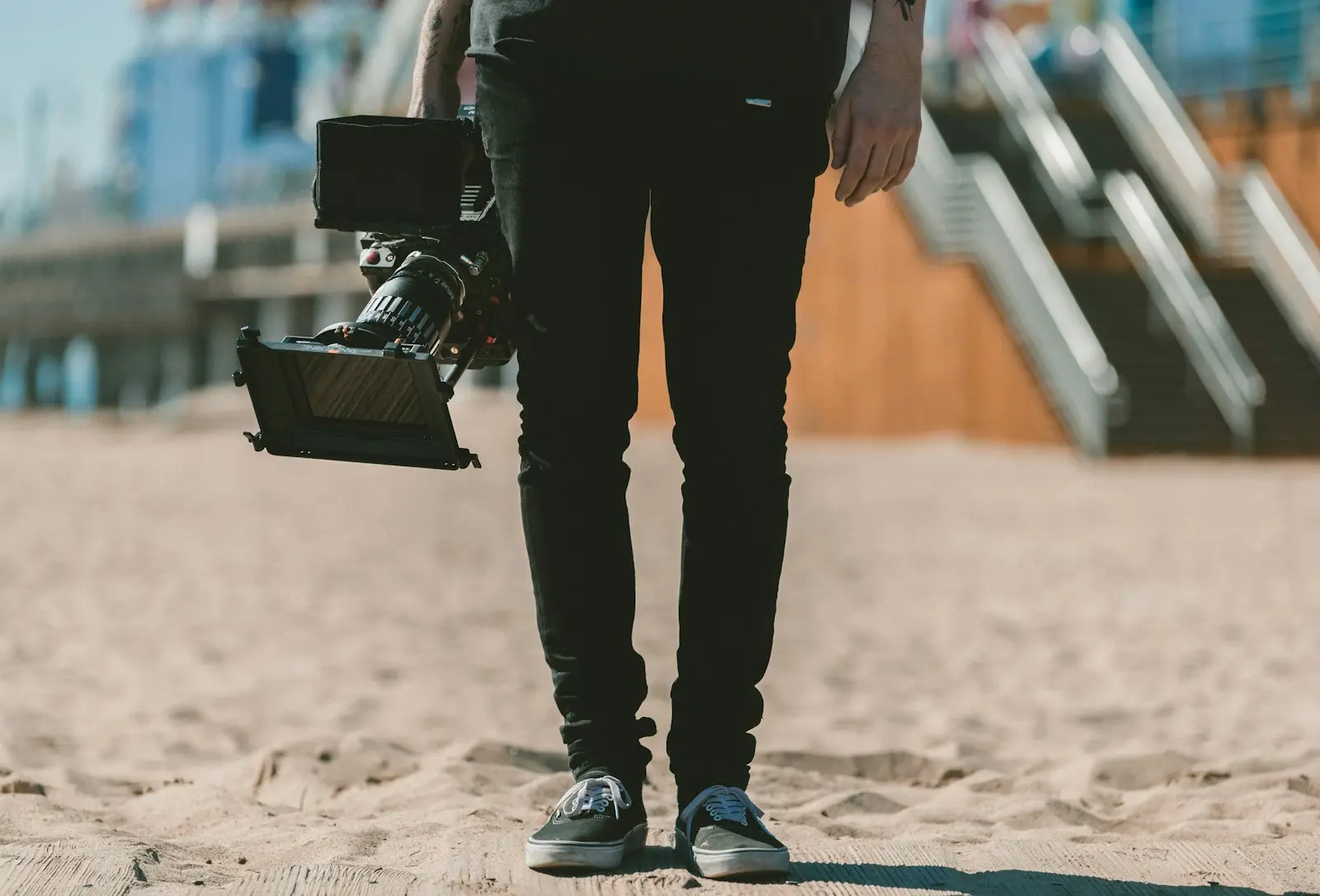Création de site internet pour vidéaste : caméraman tenant sa caméra cinéma sur la plage