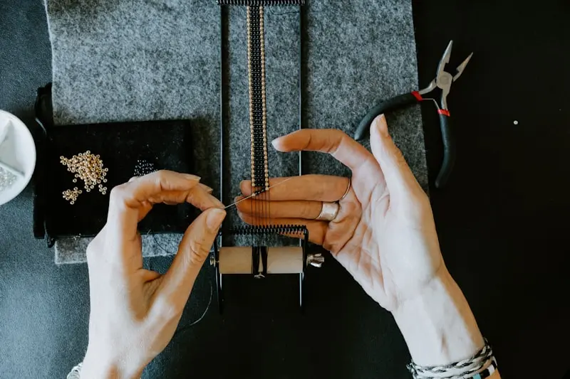 Bijoutier artisan tissant des perles sur un métier à broder, illustration pour site internet créateur