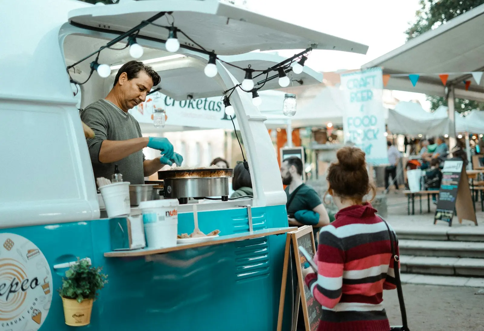 Cuisinier préparant une plancha dans un food truck lors d'un marché en plein air