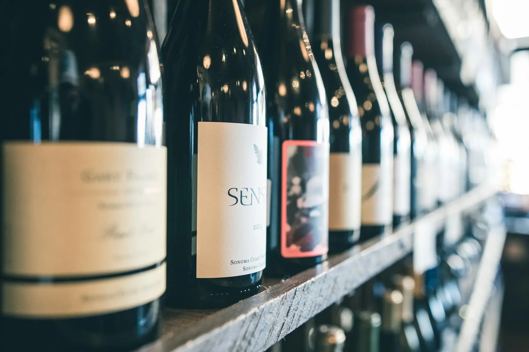 Gros plan sur l'étiquette d'une bouteille de vin parmi une rangée en épicerie fine