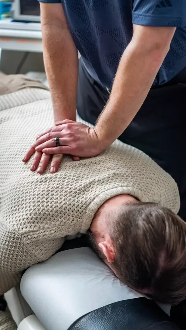 Séance de kinésithérapie : massage du dos sur table de soin en cabinet médical
