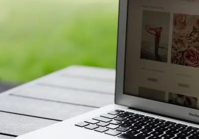 Ordinateur portable posé sur une table extérieure avec un site de fleurs affiché à l'écran