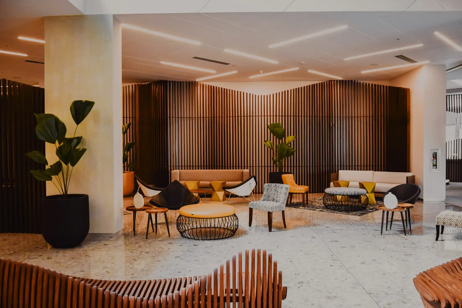 Lobby design d'un hôtel indépendant avec mobilier contemporain et claustras en bois