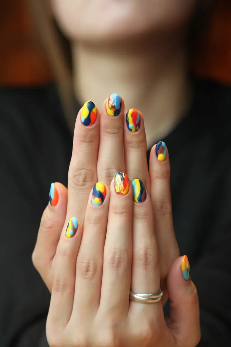 Ongles manucurés avec un nail art coloré aux motifs abstraits