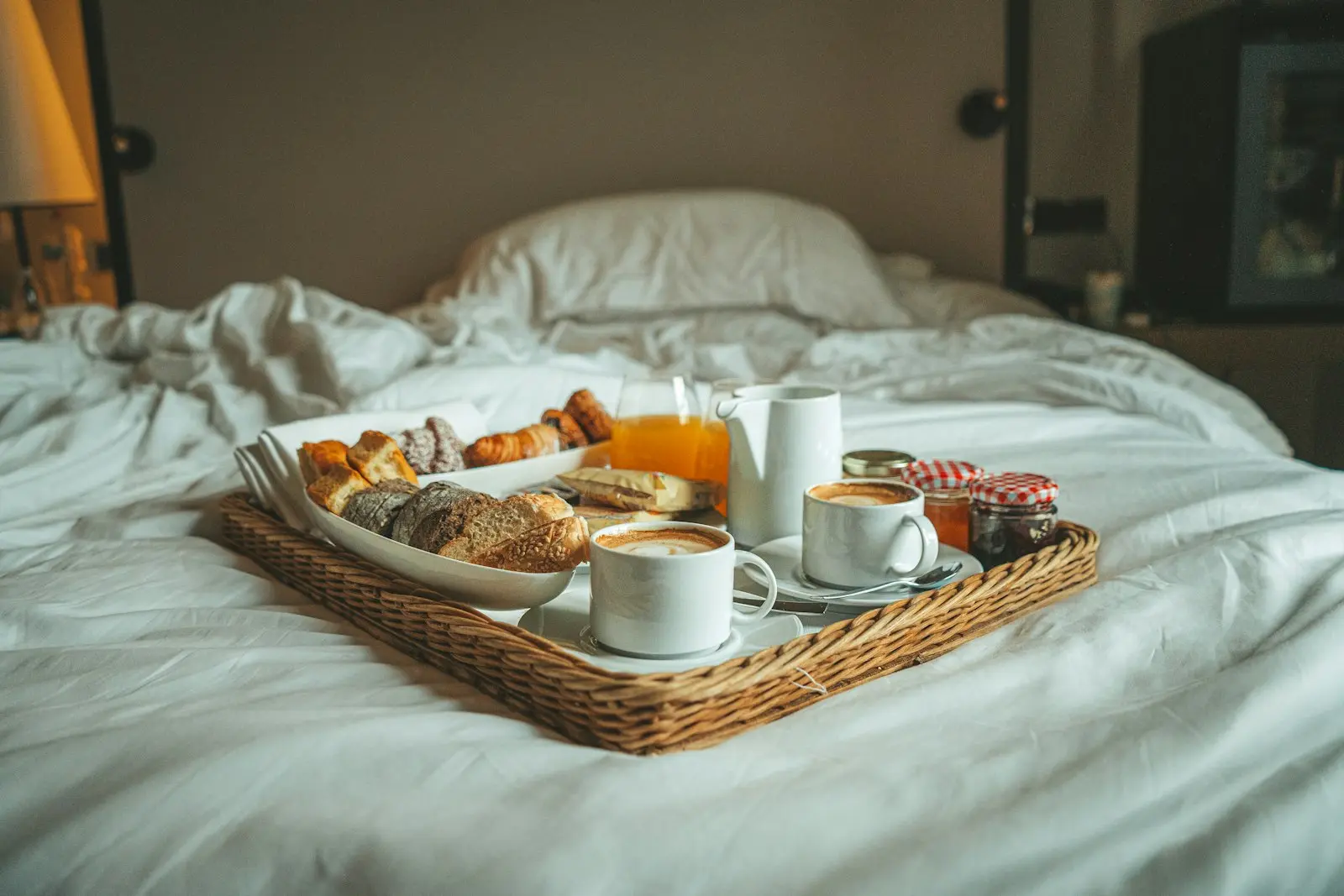Plateau petit-déjeuner complet avec viennoiseries et confitures servi au lit dans une chambre d'hôtes