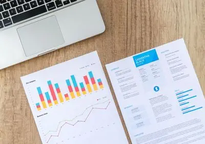 Graphiques en barres et rapport imprimé posés près d'un clavier d'ordinateur portable