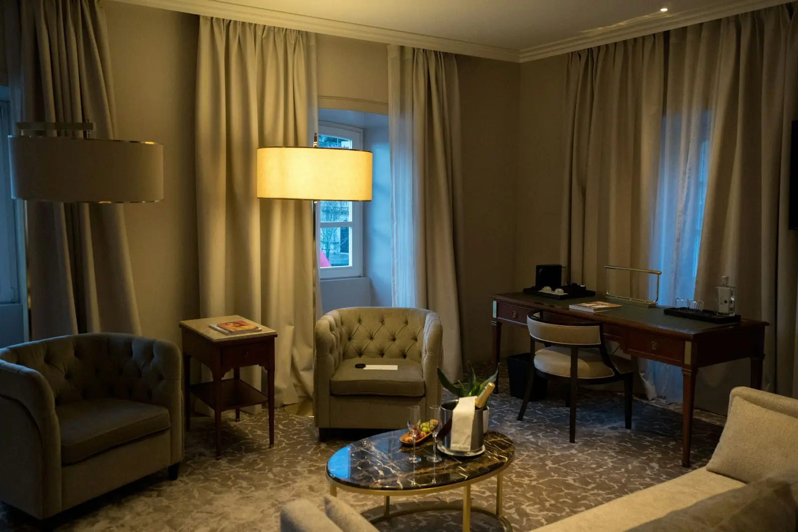 Salon cosy d'une suite d'hôtel boutique avec fauteuils capitonnés